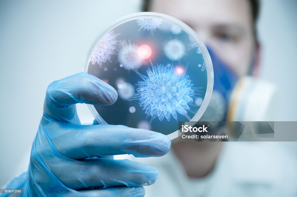 A scientist holding a Petri Dish with Virus and bacteria cells.