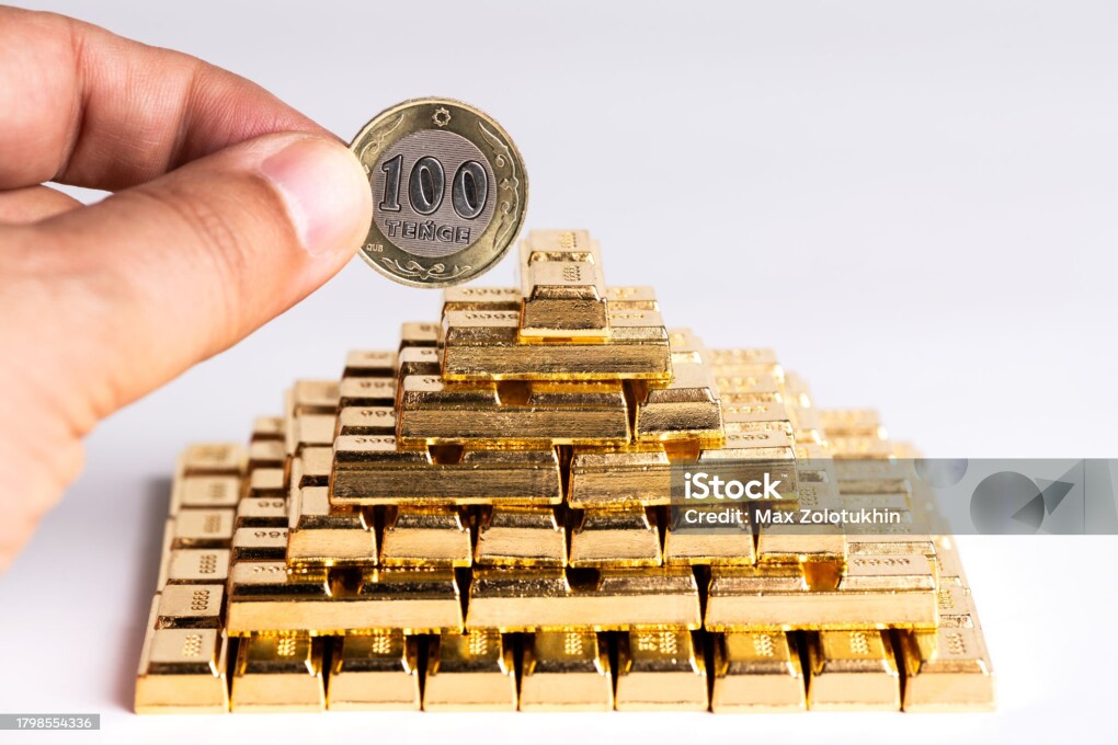 100 Kazakhstan tenge coin and pyramid of gold bars