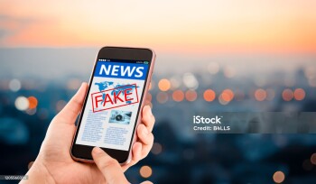 Hands holding mobile phone on blurred night city as background