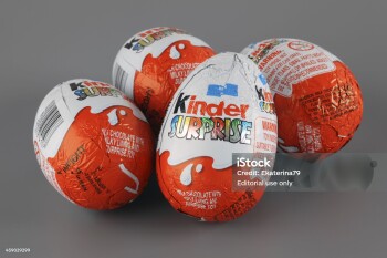 "Tambov, Russian Federation - April 04, 2013: Four Kinder Surprise Eggs on grey background. Kinder Surprise manufactured by Italian company Ferrero. Studio Shot. Each Kinder Surprise egg consists of a chocolate shell, a plastic capsule, the contents of said capsule, and an external foil wrap."