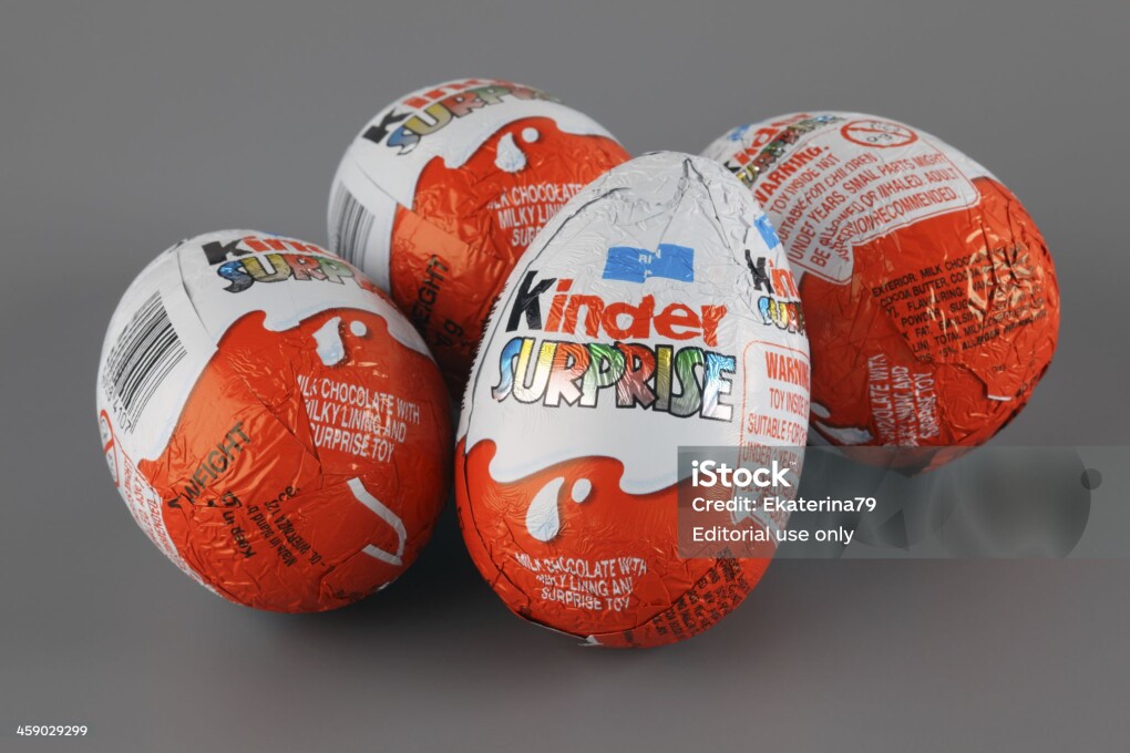 "Tambov, Russian Federation - April 04, 2013: Four Kinder Surprise Eggs on grey background. Kinder Surprise manufactured by Italian company Ferrero. Studio Shot. Each Kinder Surprise egg consists of a chocolate shell, a plastic capsule, the contents of said capsule, and an external foil wrap."