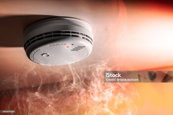 Smoke detector and interlinked fire alarm in action background with copy space