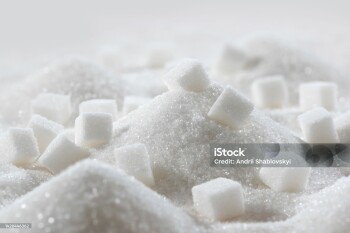 White granulated sugar and refined sugar cubes close-up in the kitchen.