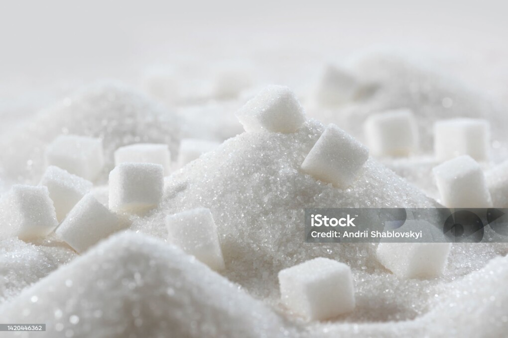White granulated sugar and refined sugar cubes close-up in the kitchen.