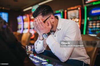 Young man loosing his money on slot machines