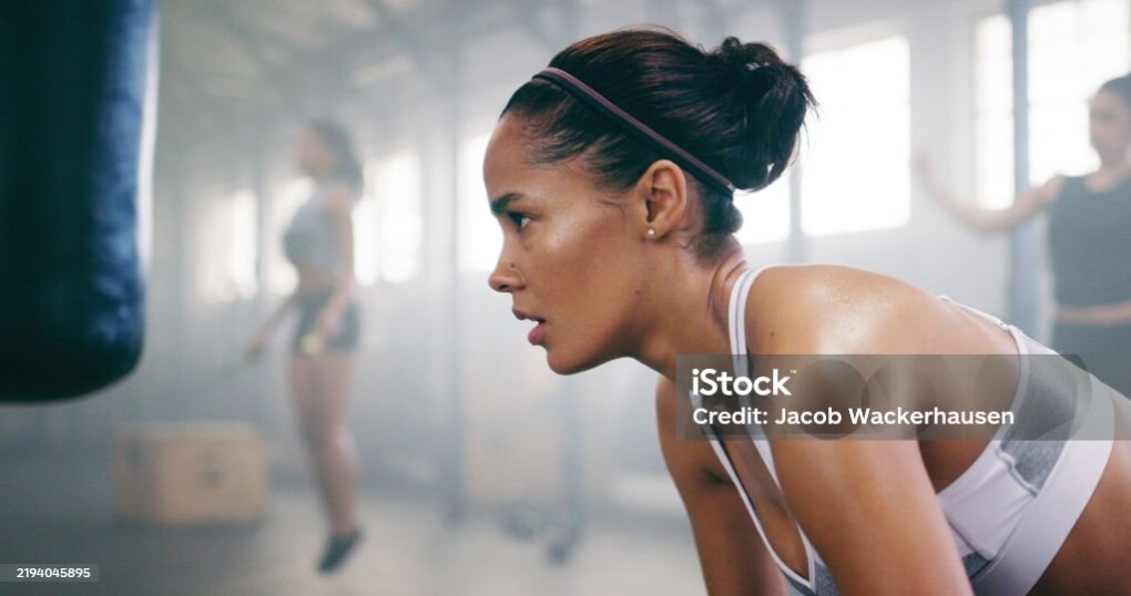 Fitness, fatigue and woman resting in gym for intense workout challenge, tired or exercise recovery. Boxing, break and athlete relax in sports club for thinking, wellness or breathing for body health