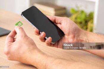 Close up of a man hands putting the sim card on the phone on a table