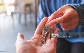 Closeup image of a real estate agent giving the keys to owner or buyer