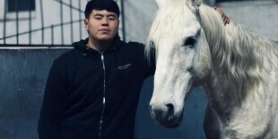 Жылқы жанына жақын жас инструктор