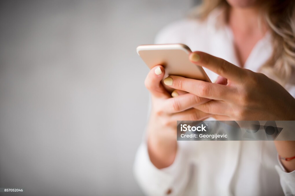 Close up of a woman using her smartphone indoors.