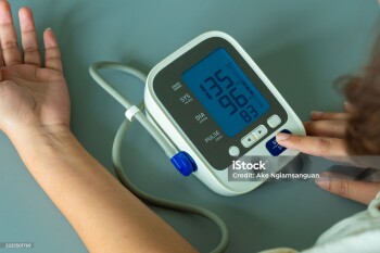 Woman checks blood pressure monitor and heart rate monitor with digital pressure gauge. Health care and Medical concept.
