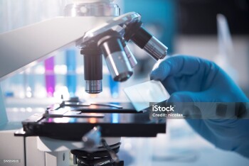 A scientist placing a slide under a microscope