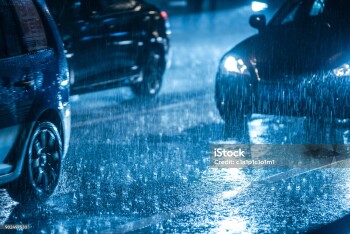 Cars driving on wet road in the rain with headlights