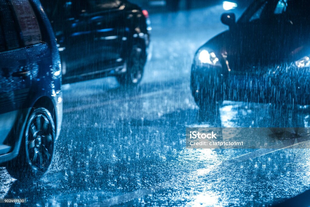 Cars driving on wet road in the rain with headlights