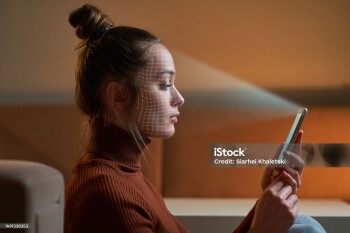 Female scans face using facial recognition system on smartphone for biometric identification. Future digital high tech technology and face id