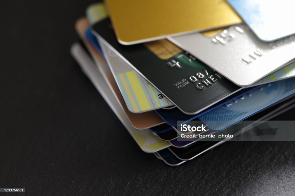 stack of multicolored credit cards on black background