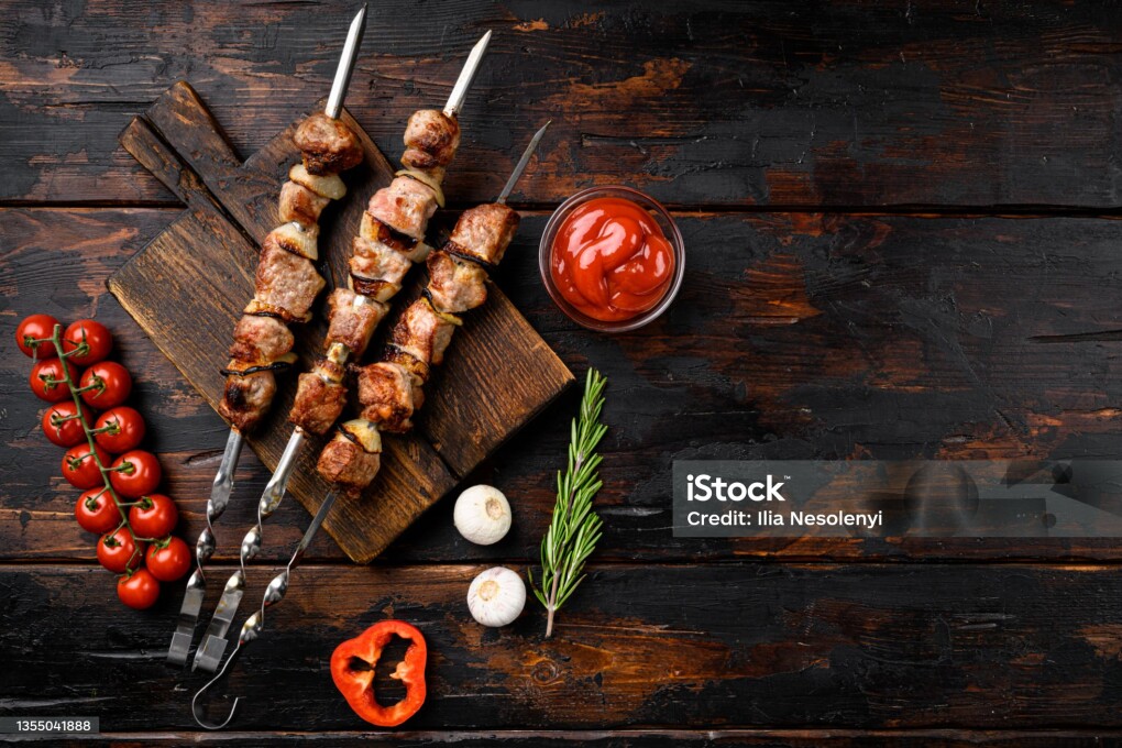 Kebabs grilled meat skewers, shish kebab set, on old dark wooden table background, top view flat lay, with copy space for text