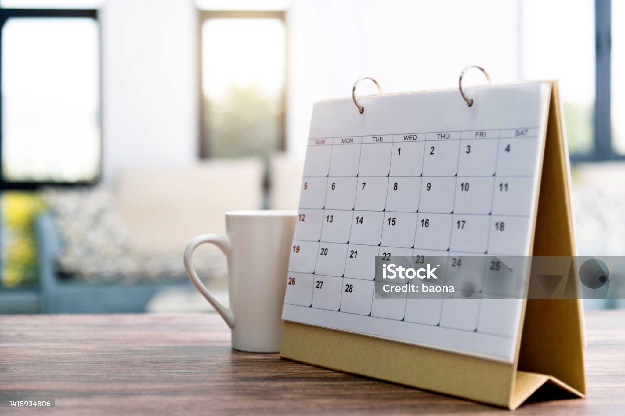 Calendar and cup on the table.