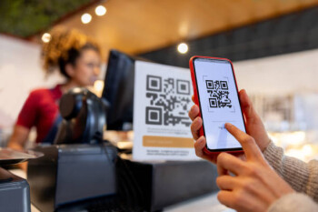 Close-up on a woman making a mobile payment scanning a QR code - small business concepts