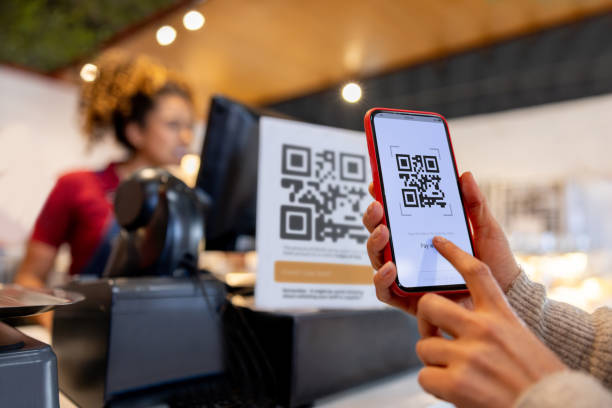 Close-up on a woman making a mobile payment scanning a QR code - small business concepts