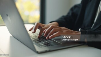 Close-up hand of man typing laptop.