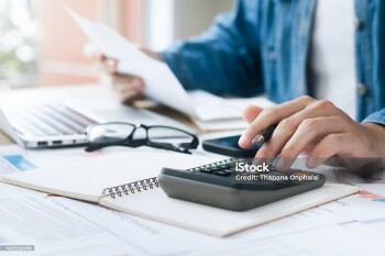 Investors are calculating profits and costs with calculators, growth and investment chart analysis, business planning and strategies to maximize sales profits. Long term business plan.