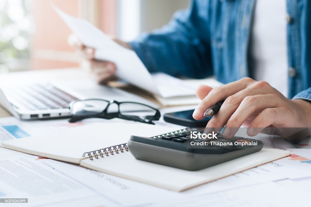 Investors are calculating profits and costs with calculators, growth and investment chart analysis, business planning and strategies to maximize sales profits. Long term business plan.