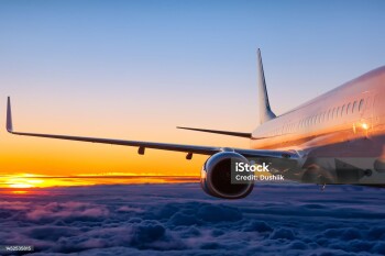 Close-up of passenger aircraft flying in the dawn sky