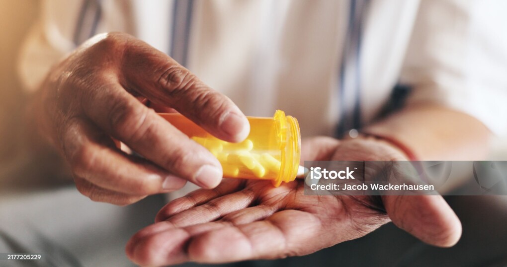Hands, pills and bottle in closeup for person with drugs, routine and schedule for health in home. Elderly patient, container and pharma product for supplements, wellness or benefits in retirement