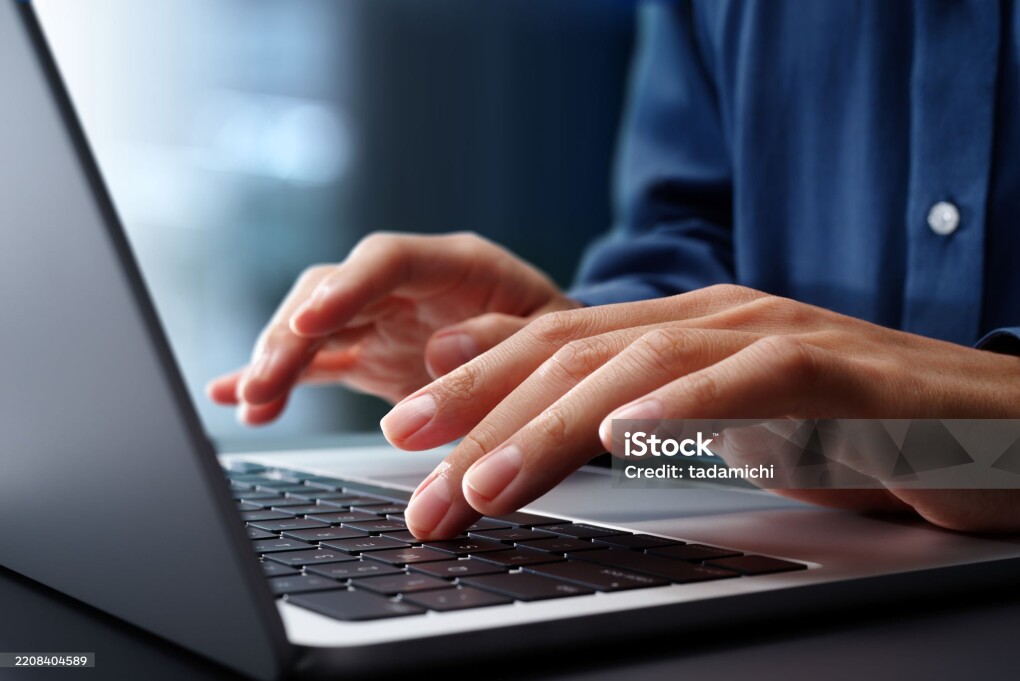 Closeup of Hands typing on laptop computer keyboard. Businessman working at desk in office. Using technologies in business.