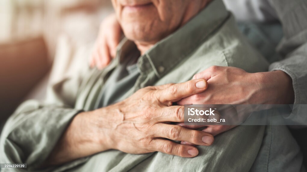 Comforting hand supporting the old man