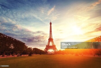 A beautiful wide shot of the famous Eifel tower under the breathtaking cloudy sky at sunrise in Paris