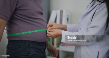 Female Nutritionist measuring waist of overweight man in weight loss clinic during giving consultation to patient with healthy and diet weight loss, Right nutrition and diet concept
