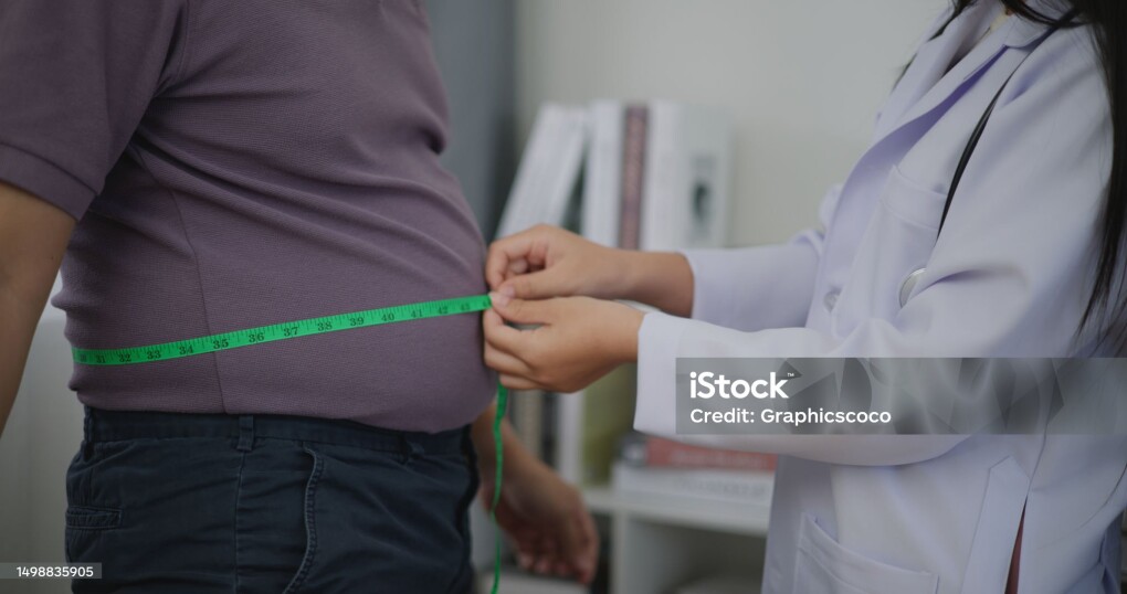 Female Nutritionist measuring waist of overweight man in weight loss clinic during giving consultation to patient with healthy and diet weight loss, Right nutrition and diet concept