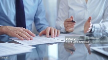 Diverse business people discussing contract papers before signing. Teamwork of lawyers are at work in office.