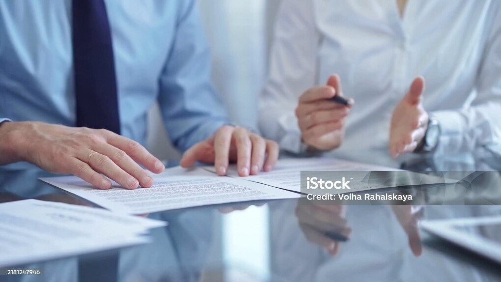 Diverse business people discussing contract papers before signing. Teamwork of lawyers are at work in office.