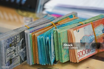 Banknotes of Kazakhstani tenge of different denominations are on the table.