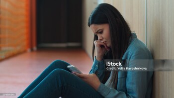 Caucasian sad upset student girl female schoolgirl woman ill reading bad news thinking pupil teen in school university college sitting on floor education study problem using mobile phone smartphone. High quality 4k footage