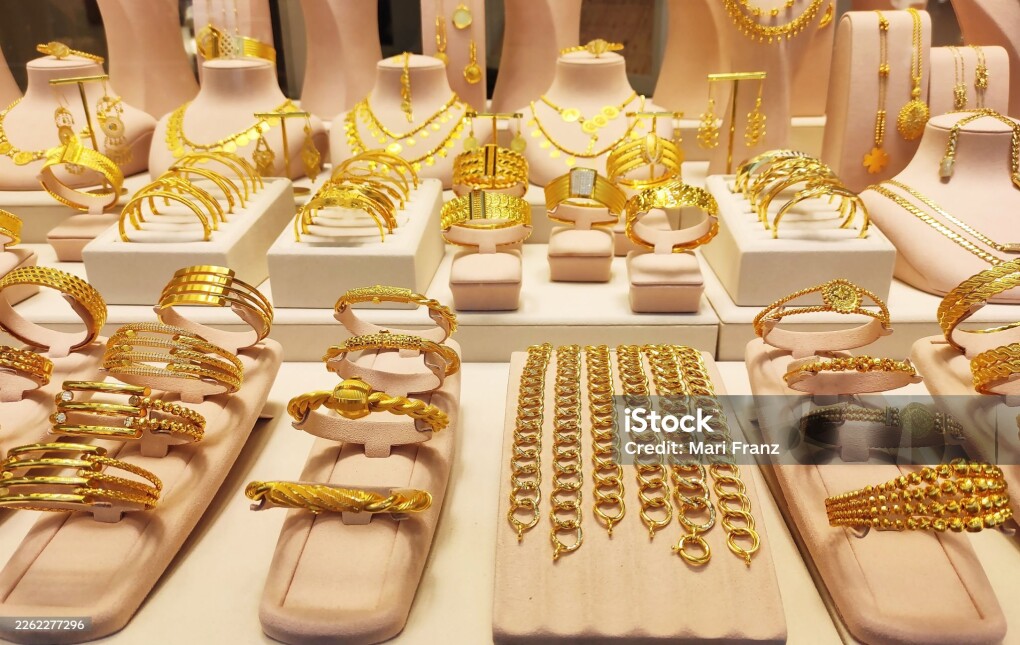 Luxury gold jewelry display in a boutique window. Elegant bracelets, necklaces and bangles