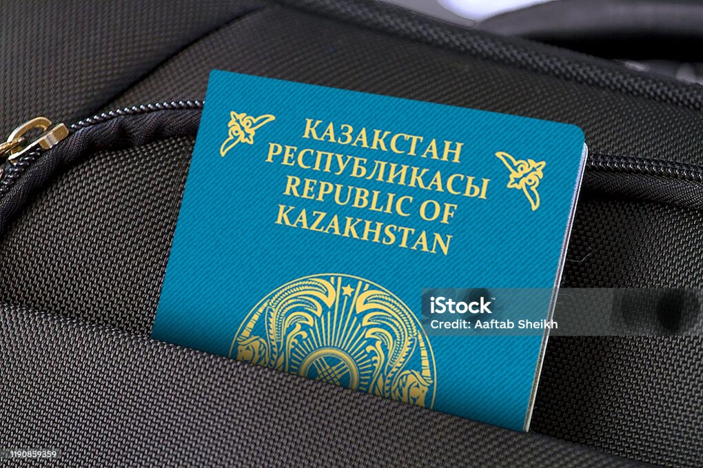 Photo of a single suitcase made of fabric material and one passport in pocket.