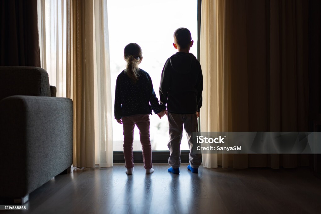Boy and girl from back, looking trough the window.