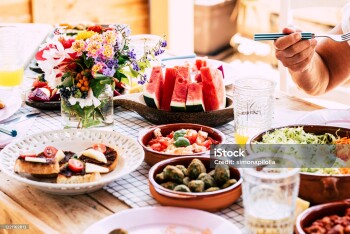 Close up of people eat healthy and vegetarian or vegan food on the table - home or restaurant celebration with friends together - fruits and vegetables to eat on the table