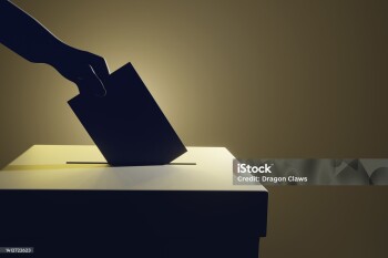 Silhouette of a hand putting a vote into the voting box on pale yellow background. Illustration of the concept of legislative election