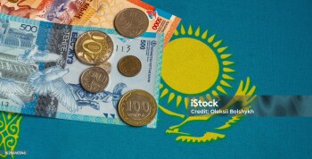 Kazakhstani tenge banknotes and coins with the national flag background