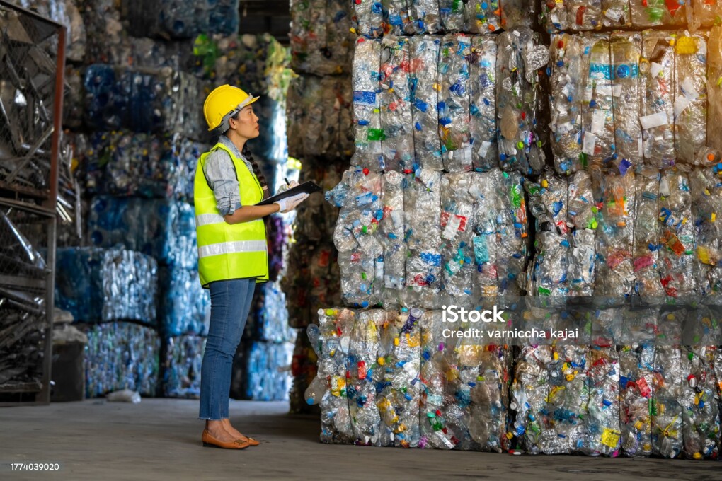 Female worker checks the stock and controls the separation of recyclable waste of the plastic waste recycling plant. And other types of waste, the concept of recycling.