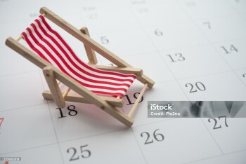 Red beach chair on white blank calendar background copy space. Annual leave travel period for relaxation concept. Period of paid time off (PTO) granted to employees by their employer.