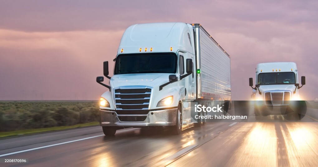 A semi-truck driving south on Interstate 5 in the Central Valley on a stormy evening.