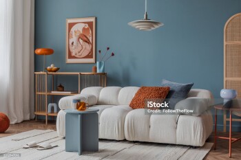 Neutral-toned living room corner with layered textiles, a cushioned sofa, and minimalistic decor for a calm ambiance.