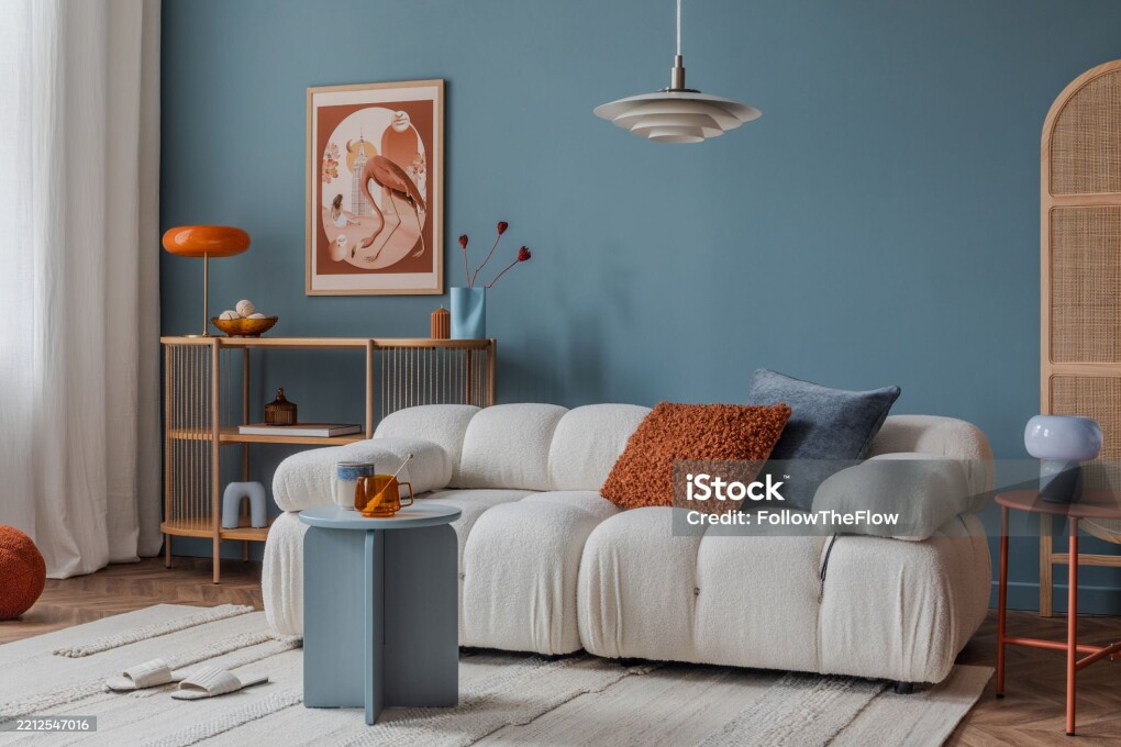 Neutral-toned living room corner with layered textiles, a cushioned sofa, and minimalistic decor for a calm ambiance.