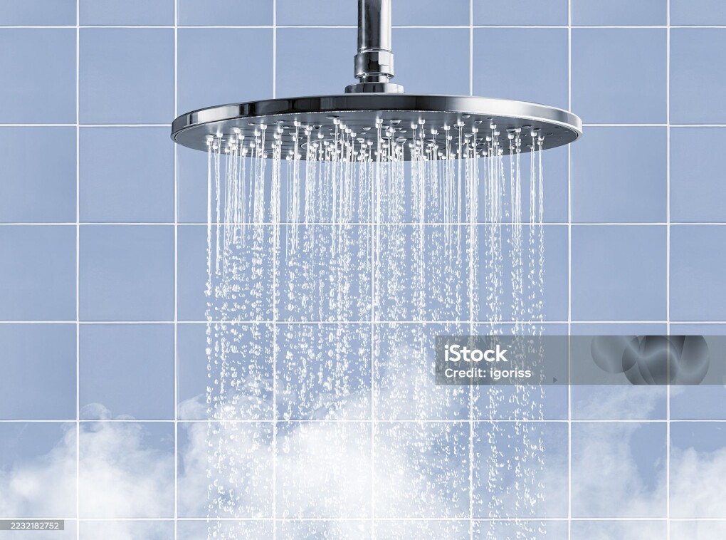 Rainfall shower head that creates a captivating water display accompanied by soothing steam on blue tiled wall background